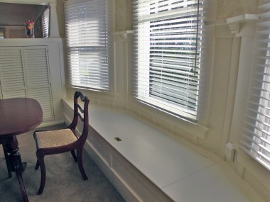 Formal dining room window seat, perfect for hiding the table leaf, linens, and decorations.