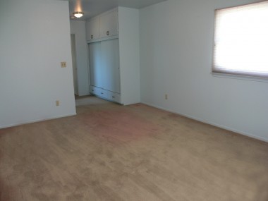 Spacious master bedroom with private 3/4 bathroom and large closet. Carpeting is sun-faded, but we're told there might be hardwood floors underneath!