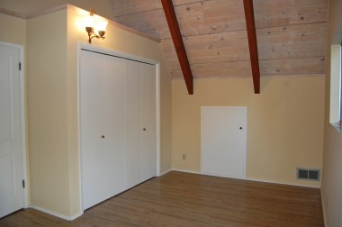 One of the two upstairs bedrooms. Notice the cathedral wood ceilings, and ample closet space!
