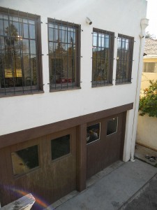 View the 2-car garage with original solid wood doors from the back deck. Garage is conveniently tucked away behind the house and under the living room. There is also a separate carpenter's workshop with separate entrance, along with a bonus/laundry room on the same level. 3105 Pine St., Riverside