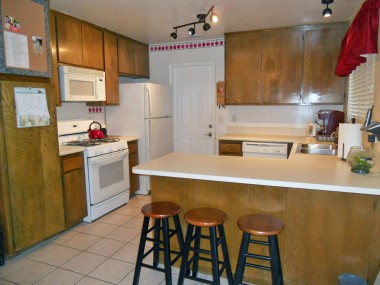 Modern kitchen with gas stove and built-in microwave, dishwasher, pantry, and lots of cabinetry.