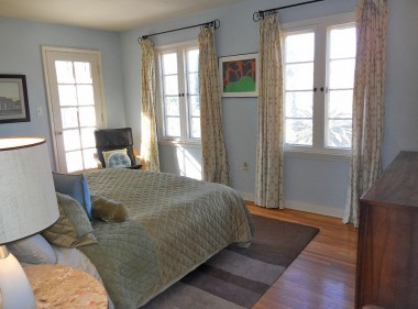 Master bedroom with original hardwood floors, lighting fixtures, and French door to private balcony. 3105 Pine St., Riverside