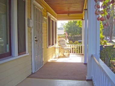 Breezy front porch.... take note of the gorgeous wood ceiling.