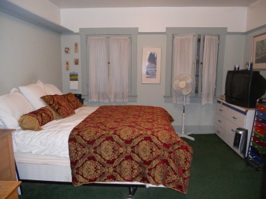 One of the three downstairs bedrooms. There is central air in the house that works, even though there is a free-standing fan in the photo.