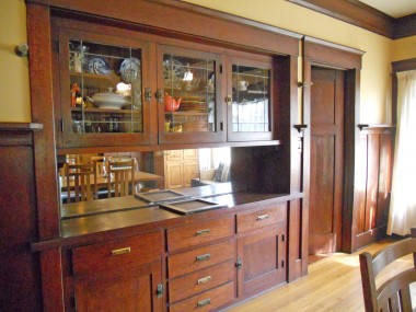 Built-in China hutch with leaded glass and a plate rail that runs the perimeter of the dining room.