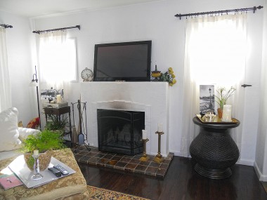Wood-burning fireplace flanked by two windows that allow natural sunlight to flow in unabashedly. 4081 Larchwood Pl., Riverside
