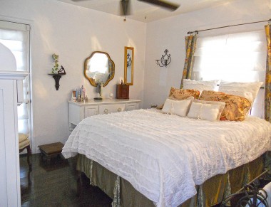 Master bedroom with original hardwood floors, walk-in closet, double-paned window, ceiling fan, and French door to private backyard. 4081 Larchwood Pl., Riverside