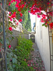 Beautiful bougainvillea-laced arbor leading to the side yard with hand-laid brick walkway to custom front yard gate. 4081 Larchwood Pl., Riverside