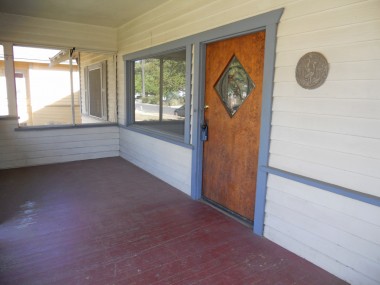 Large front porch with original front door and large windows.