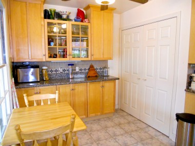 Breakfast nook area with built-in hutch -- laundry behind the folding doors (washer/dryer included with sale).