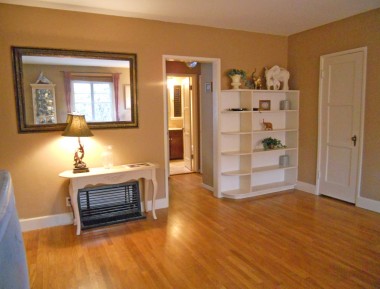 Alternate view of living room towards bedrooms. Built-in shelving and front coat closet (with mail slot in the closet).