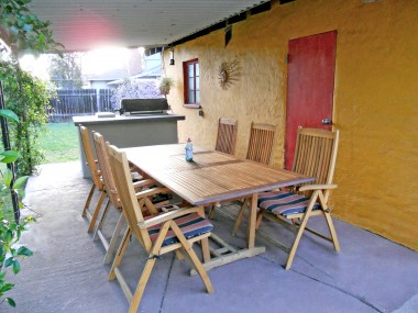 Covered patio adjacent to the garage, including built-in BBQ with refrigerator overlooking the koi pond.