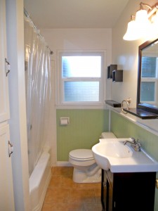 Updated bathroom with tile floor, newer vanity, wainscoting and deep linen closet.
