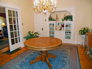 Formal dining room with original hardwood floors (old floor furnace that is no longer needed as this home now has central air/heat) and a built-in China hutch.