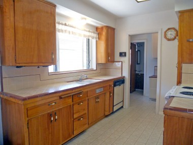 Alternate view of kitchen with dishwasher, original tiled counter tops and privacy pocket doors to completely close off the kitchen.