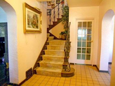 Foyer with tile floor. Living room to the left and formal dining room to the right, and straight ahead through glass paneled French door is kitchen and basement access.