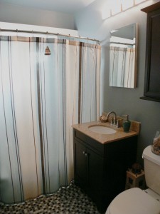 Remodeled hallway bathroom with tile floor, newer vanity, new double pane window, light fixture and paint.