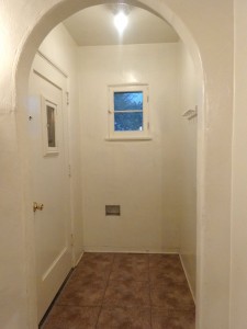 Entry with linoleum, original ceiling fixture, coat hooks and mail slot.
