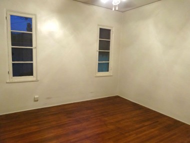 One of four bedrooms total (two in each unit).  Three have exposed original hardwood floors;  one has carpeting.