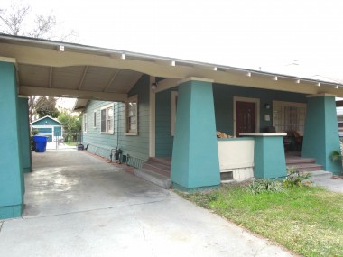 Covered carport, large front porch, and 1-car detached garage in back corner of yard, with alley access too.