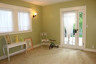 Back bedroom with carpeting, walk-in closet and sconce lighting, and with charming door leading to back patio.