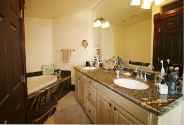 Master bathroom boasts dual sinks with granite counter top, spa tub, and private water closet.