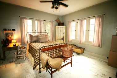 Spacious back bedroom with ceiling fan, hardwood floors, and charming windows.