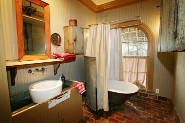 Remodeled bathroom with vessel sink, claw foot tub, and brick floor. So charming!