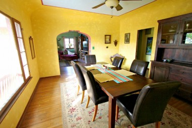 Large formal dining room with coved ceiling and archway leading into the living room.