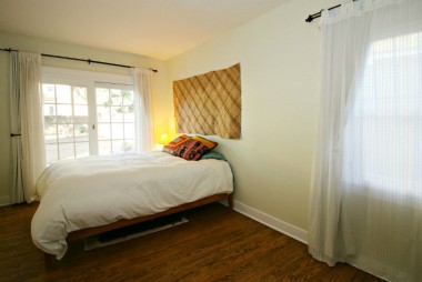 Master bedroom with sitting area (see next photo), with hardwood floors, ceiling fan, and newer slider to backyard. 