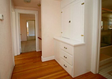 Upstairs hallway with linen closet and newer oak floors.