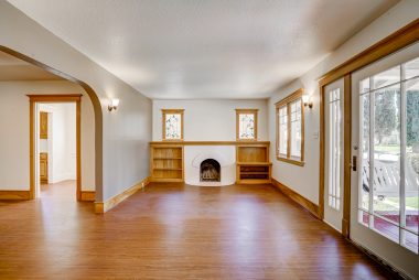 Living room with fireplace and newly laid laminate flooring (can easily be removed without harming original hardwood floors that are underneath). 