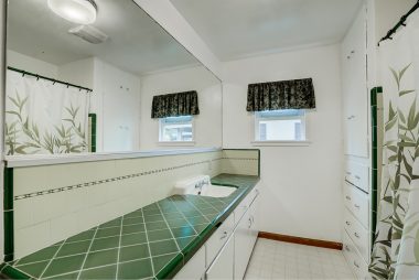 Bathroom with original green retro counter top tile and ribbon tile back splash, with space for additional sink if needed. Original tiled tub/shower enclosure too.