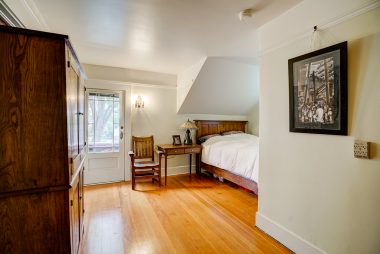 Second of two bedrooms facing the front of the house, both with doorway access to the breezy balcony. Gorgeous original pine floors too.