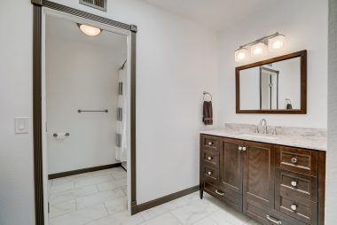 Brand new remodeled bathroom with tile floor, two separate vanities, and a soaking tub.