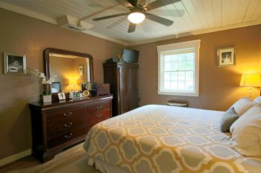 Master bedroom with ceiling fan, hardwood floors, and double pane windows.