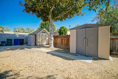 Fenced area behind the landscaped yard with room for garden, pool, and RV parking. Three sheds shall remain with the property.