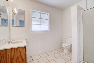 Guest unit bathroom with shower and tile flooring.
