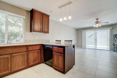 Kitchen with breakfast bar (stools included) opens up into family room with slider to back yard, and corner fireplace.
