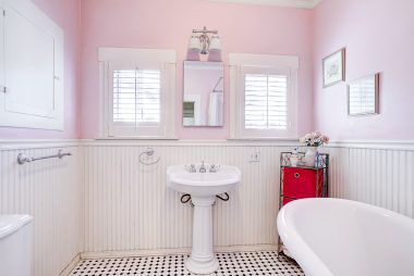 Remodeled hallway bathroom with tile floor and claw foot tub.