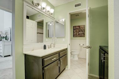 Hallway bathroom with shower in tub.