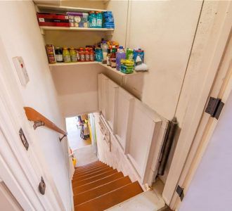 Pantry with pull-up trap door in open position, which leads to the garage and the finished basement and storage areas.