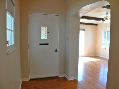 view of hardwood floor entry, with step-down living room to the right