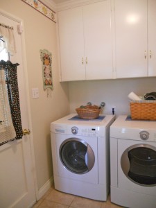 Indoor laundry room with plenty of cabinetry and space for today's modern appliances.