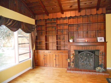 Built-in bookshelves that frame the wood-burning fireplace.