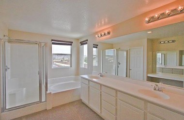 Master bathroom with dual sinks, soaking tub, and an enormous walk-in closet with two separate entry doors (one for each person).