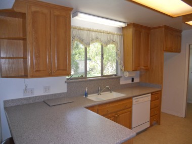 Remodeled kitchen with Corian counter tops, new cabinetry, dishwasher, lazy susan, and breakfast bar in addition to a dining room.