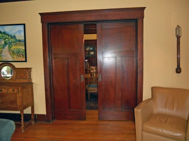 View of functional original pocket doors that separate the iving room from the dining room.