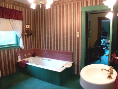 Upstairs bathroom with soaking tub, pedestal sink, and cabinetry (not pictured).