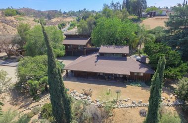 Aerial photo of main house and guest quarters over the 3-car garage. Almost every rock on this property has its place among the walking paths and orchard. This estate is a true gem!
